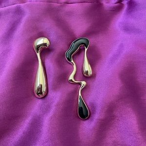 Abstract art earrings in gold with black enamel detail.